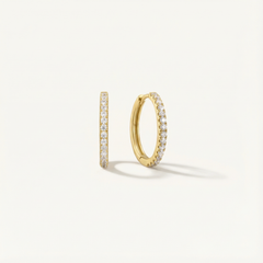 Gold hoop earrings with embedded diamonds on a light gray background