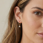 Close-up of a woman wearing a gold earring 