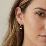Close-up of a woman wearing a gold earring 