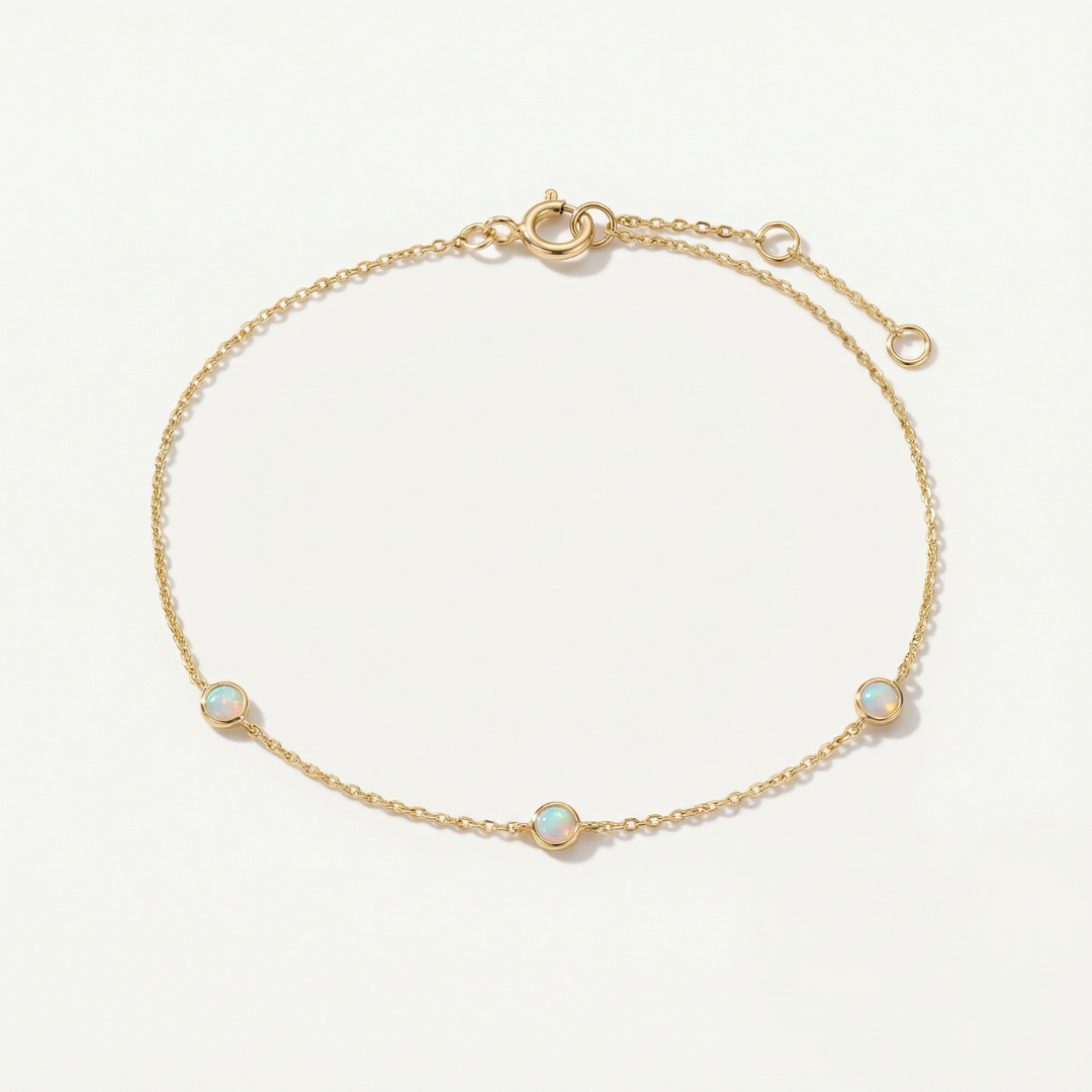 Gold bracelet with opal stones on a light beige background