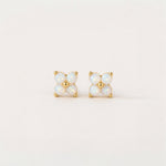 Pair of gold and opal stud earrings on a light beige background