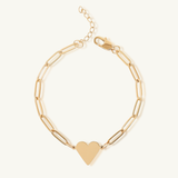 Gold bracelet with a heart charm on a white background