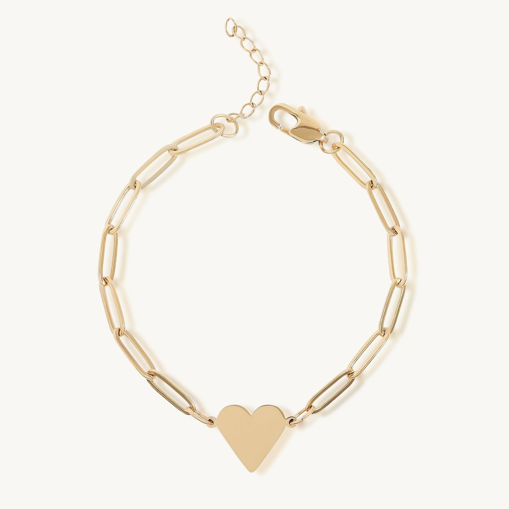 Gold bracelet with a heart charm on a white background