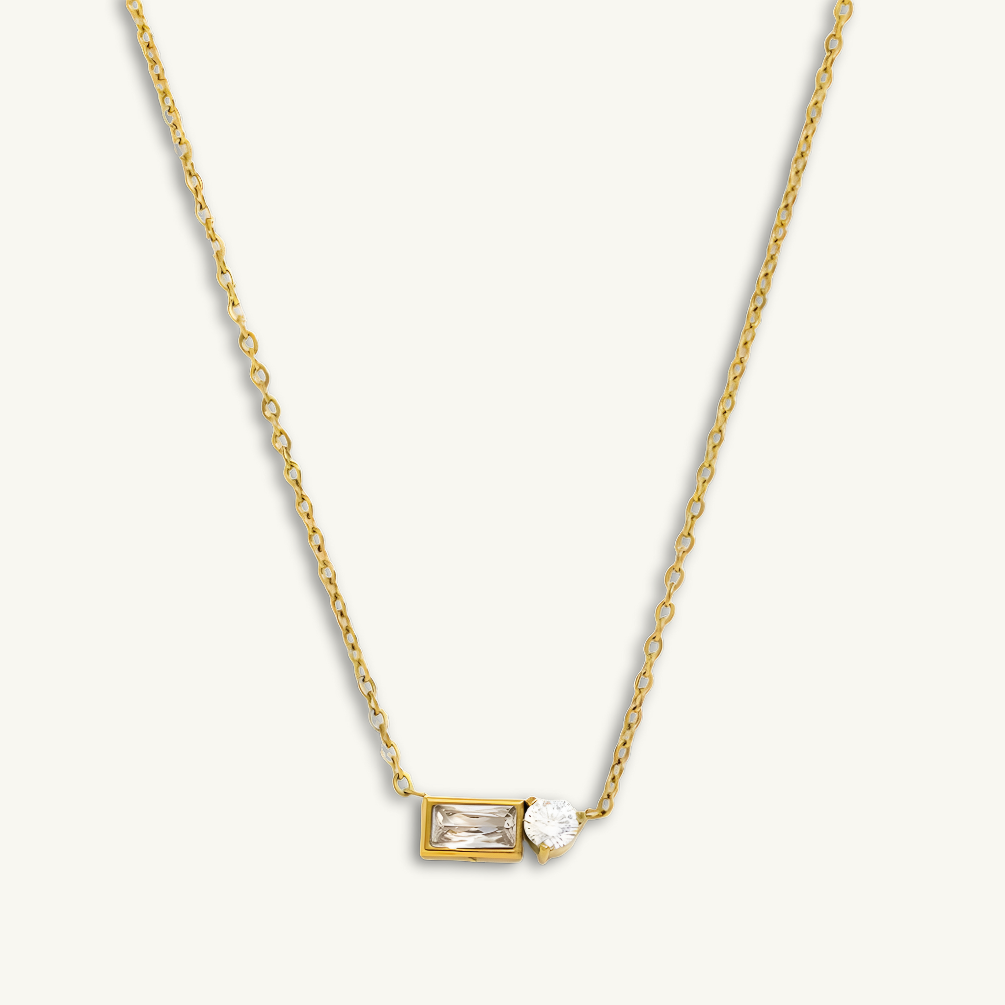 Gold necklace with a rectangular pendant on a white background