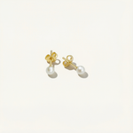 Pair of dainty pearl earrings with gold studs on a white background