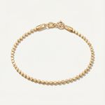 Gold dot bracelet on a light beige background