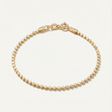Gold dot bracelet on a light beige background
