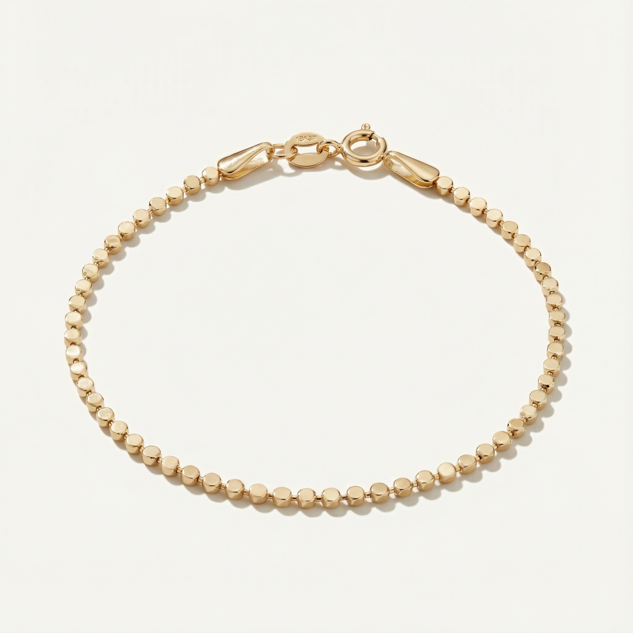 Gold dot bracelet on a light beige background