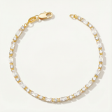 Gold and clear crystal tennis bracelet on a white background
