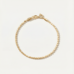 Gold bracelet on a light beige background