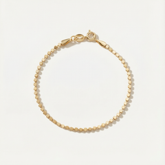 Gold bracelet on a light beige background