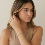 a women wearing a gold figaro chain bracelet