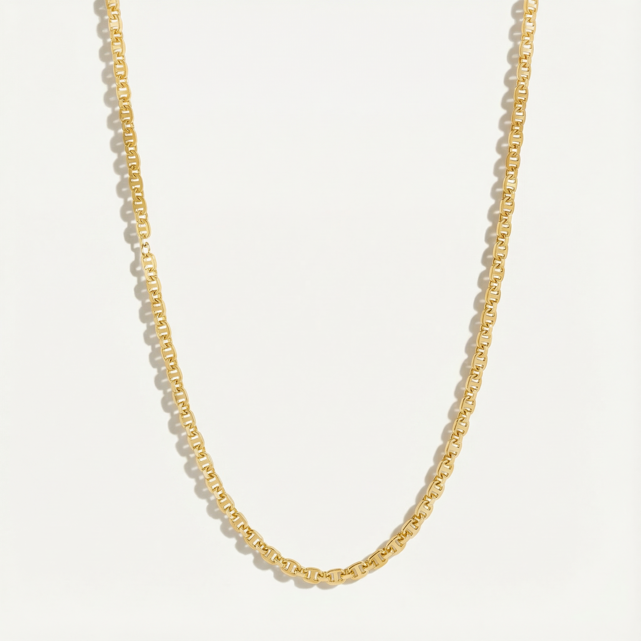 Gold chain necklace on a light gray background
