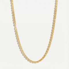 Gold chain necklace on a light gray background