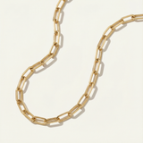 Gold chain necklace on a light beige background