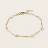 Gold bracelet with pearls on a light beige background