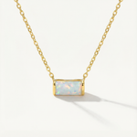 gold opal necklace against a white background