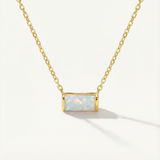 gold opal necklace against a white background
