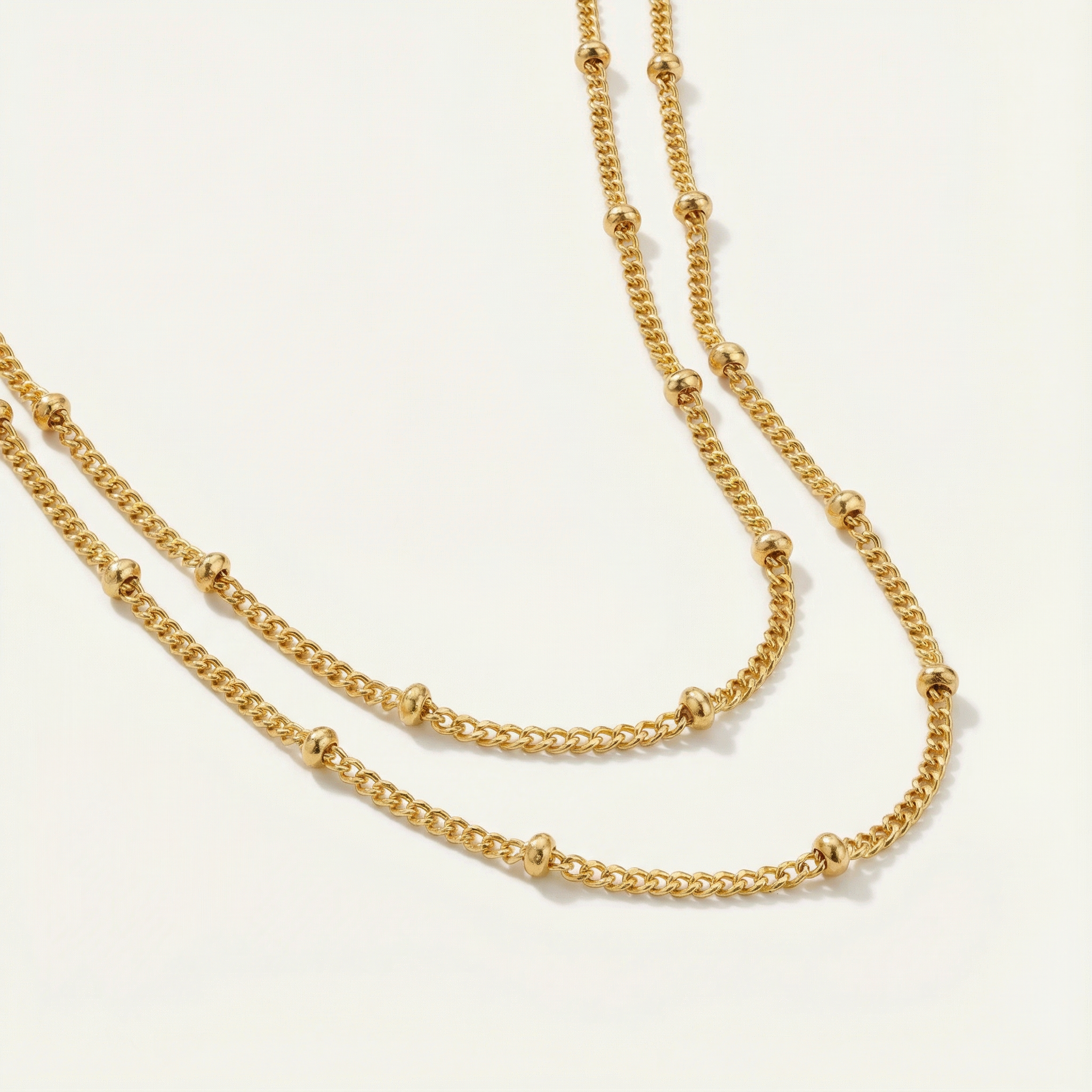 Gold satellite necklace on a light gray background