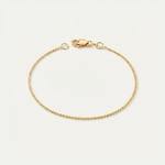 Gold dainty bracelet on a light beige background