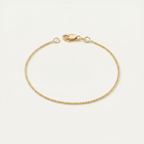 Gold dainty bracelet on a light beige background