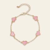 Bracelet with pink heart charms on a beige background