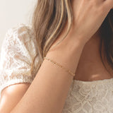 Woman wearing the Figaro Bracelet, an 18k gold filled flat chain bracelet by Kate Gates Jewelry