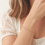 Woman wearing the Figaro Bracelet, a gold bracelet stack essential that's tarnish-free by Kate Gates Jewelry